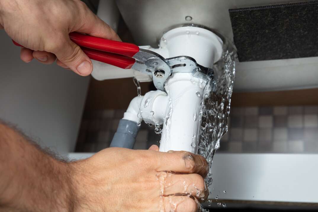 Repairing a leaking pipe under a sink